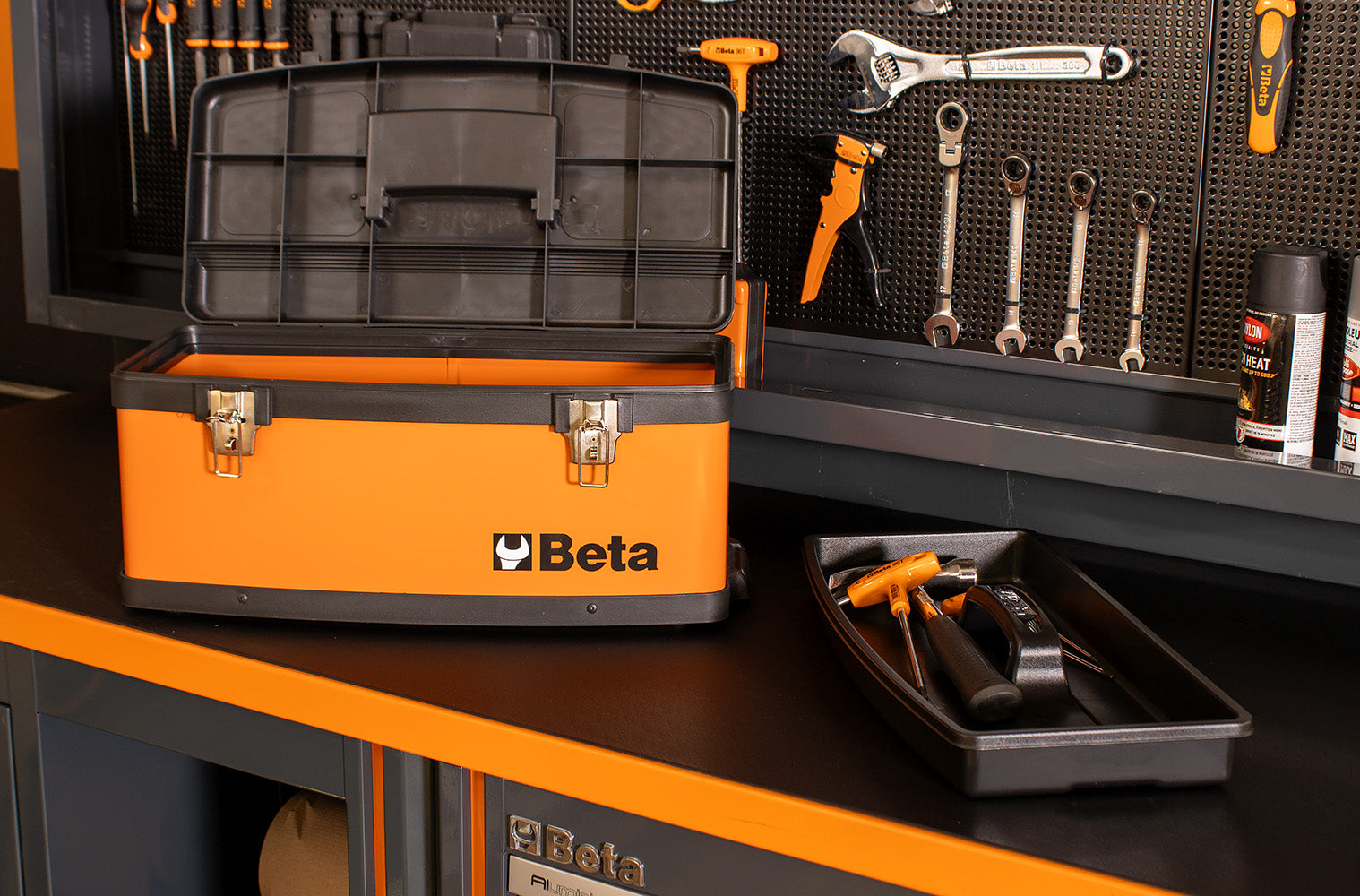 Orange and black tool box with tools on a workbench