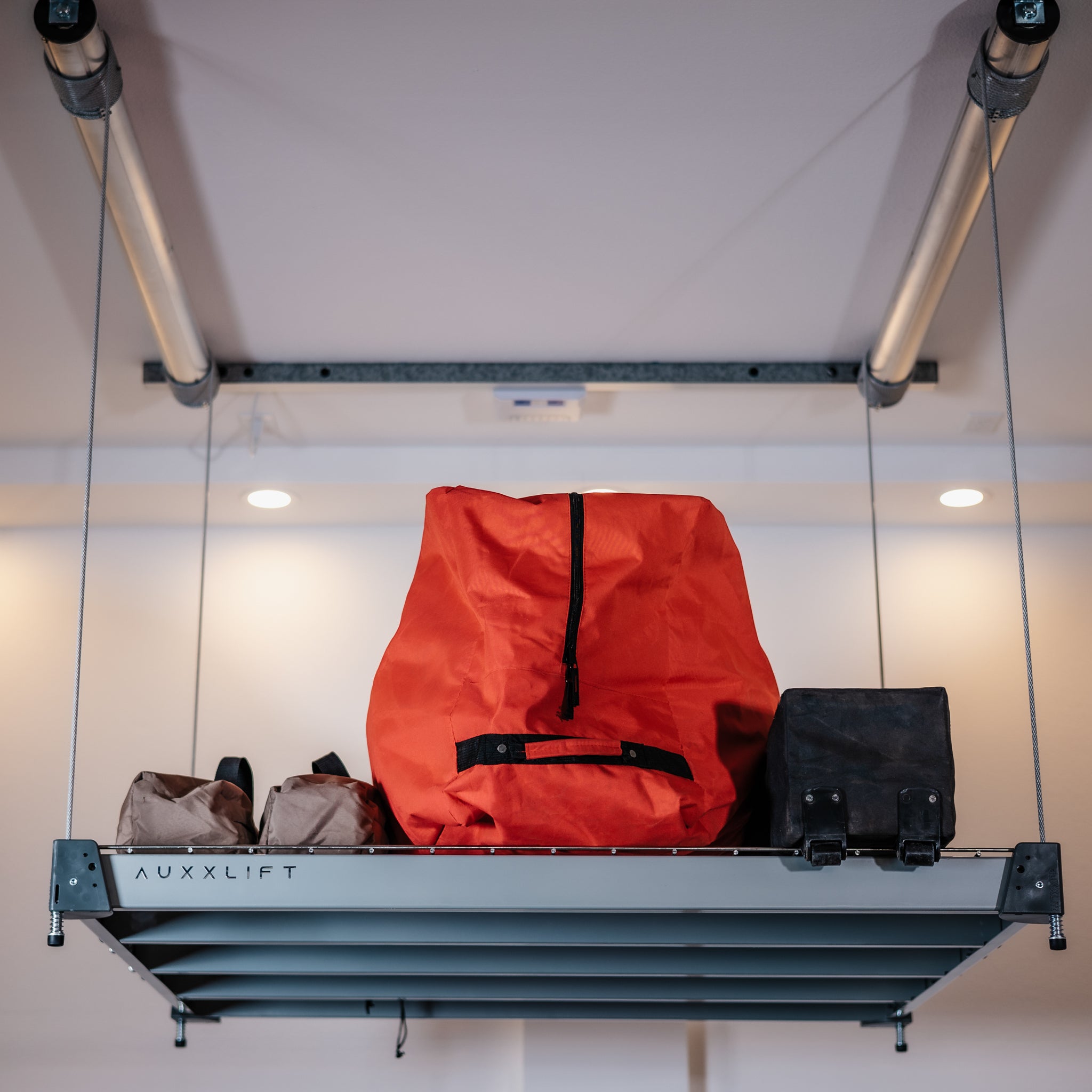 Auxx-Lift Motorized Garage Ceiling Storage Lift lowered with orange bag in garage