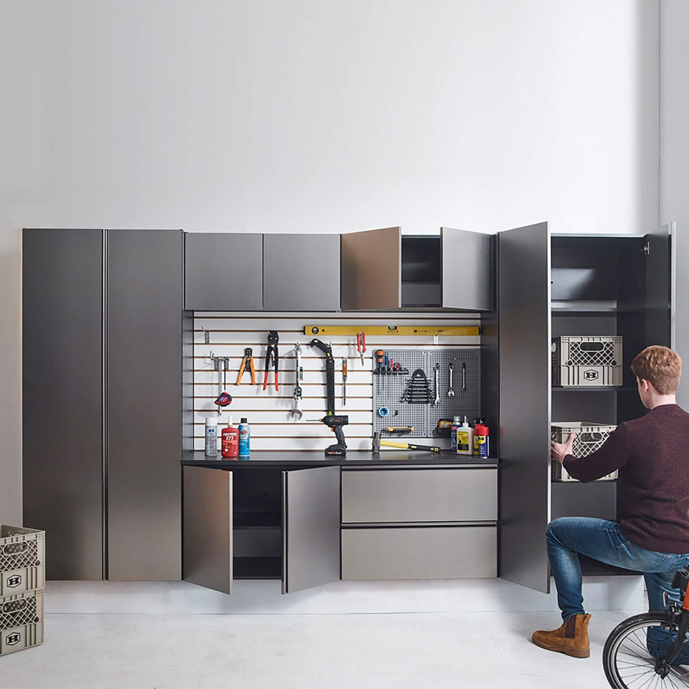 Modern garage storage system with tools and equipment, featuring a person interacting with the cabinets.